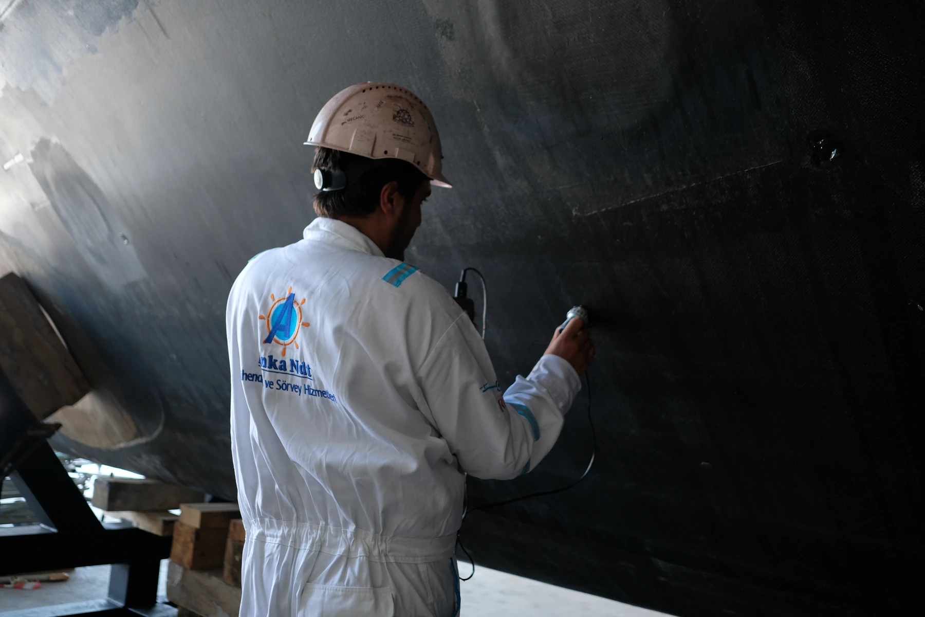 An ANKA NDT technician inspects a composite boat hull with a contact probe