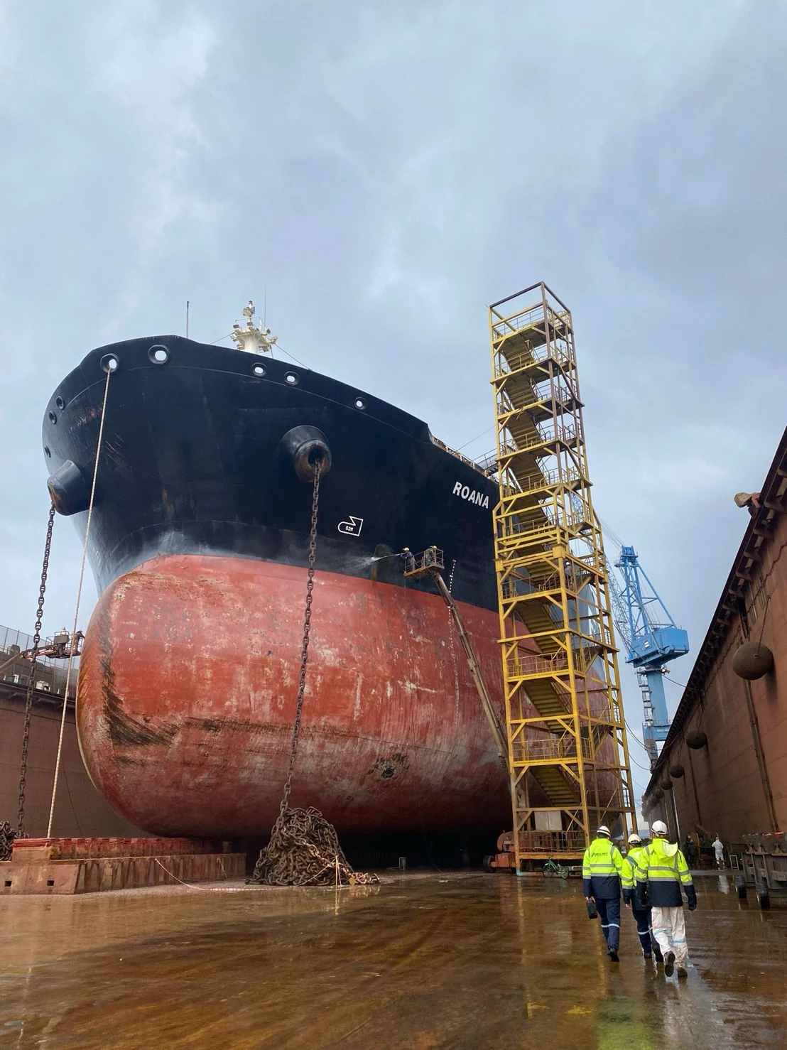 The bow of the tanker in dry dock, with the ANKA NDT team walking alongside